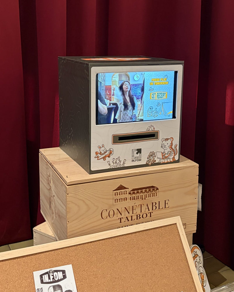 Receipt Booth with an illustrated front on a wooden crate in front of a red curtain
