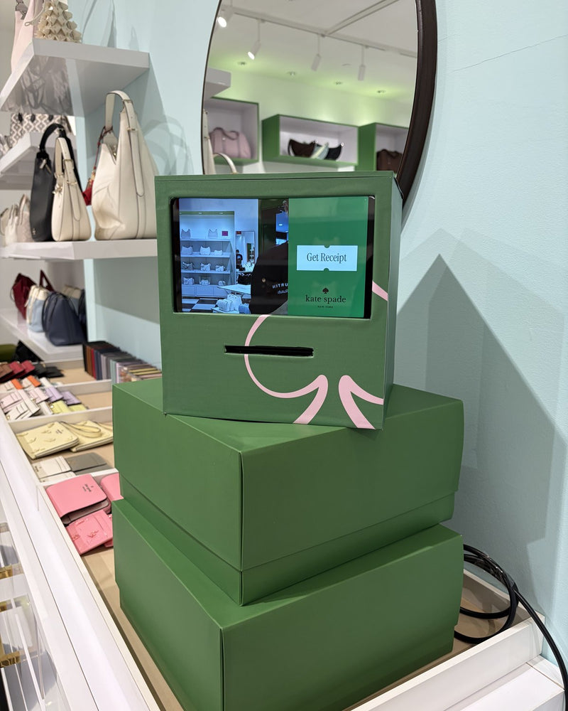 Green Receipt Booth stacked on green boxes in a Kate Spade store