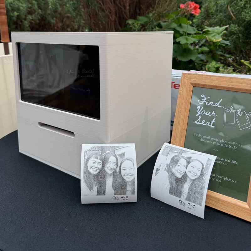 Cream Receipt Booth beside two printed photos and a framed seating sign