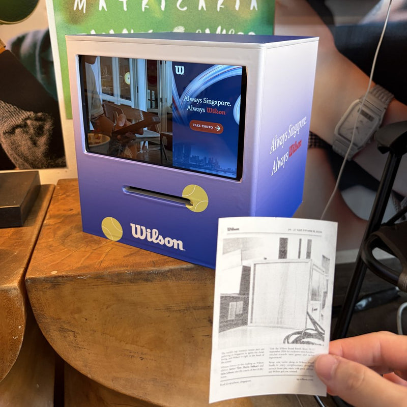 Receipt Booth with a Wilson-branded front and a printed receipt held in front of it